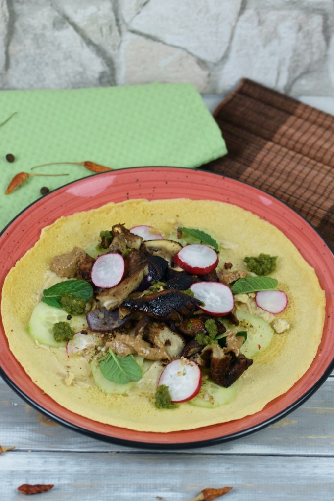 Pilz-Shawarma mit Tortilla auf rotem Teller.