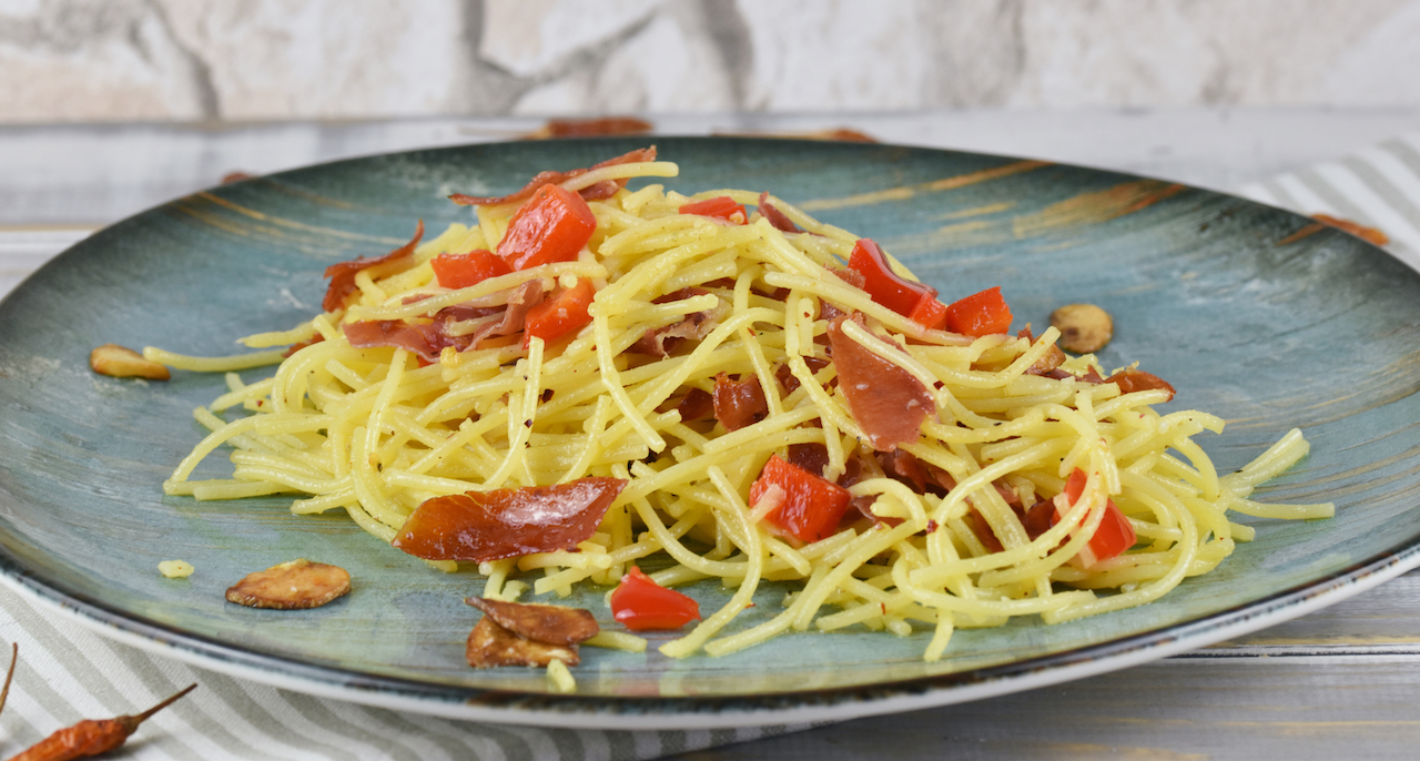 Spaghetti aglio e olio e peperoncino auf einem türkisen Teller.