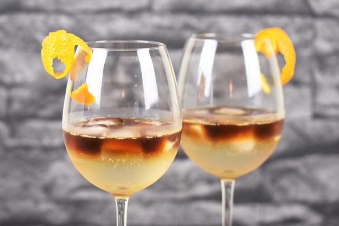 Zwei Espresso Tonic in Weingläsern. Hintergrund dunkel.