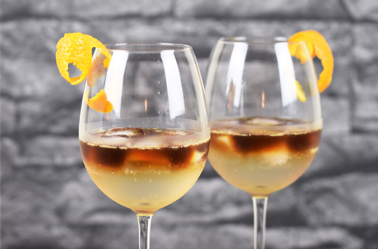 Zwei Espresso Tonic in Weingläsern. Hintergrund dunkel.