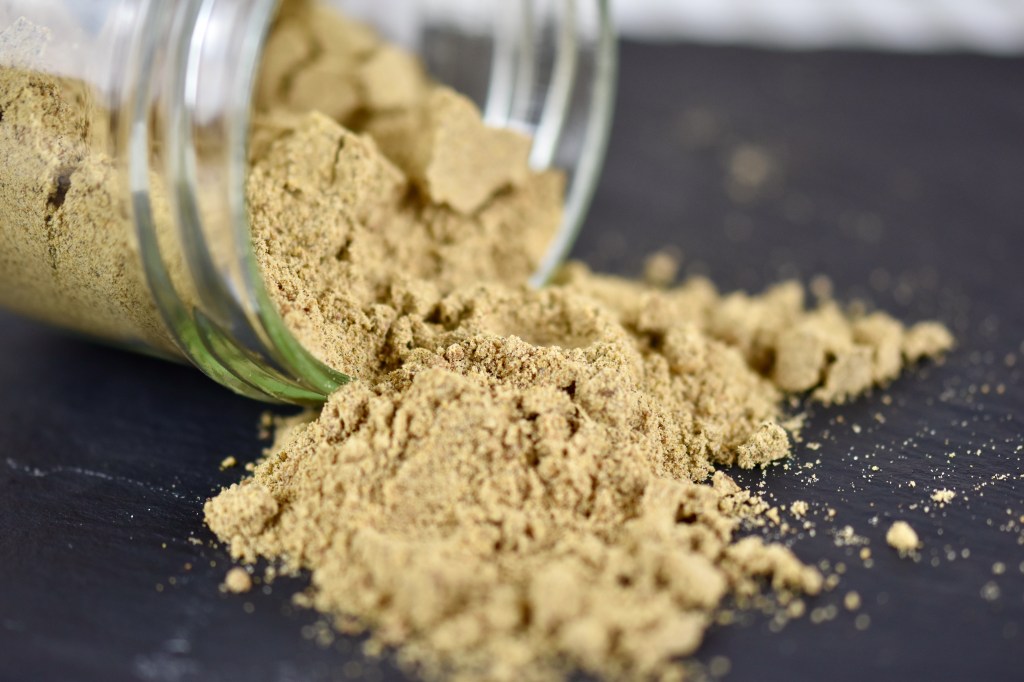 Chat Masala in einem Glas, das umgekippt ist. Etwas von dem Gewürz ist rausgefallen.