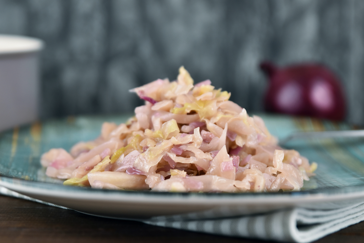 Sauerkraut geschmort auf einem blau-grünem Teller.