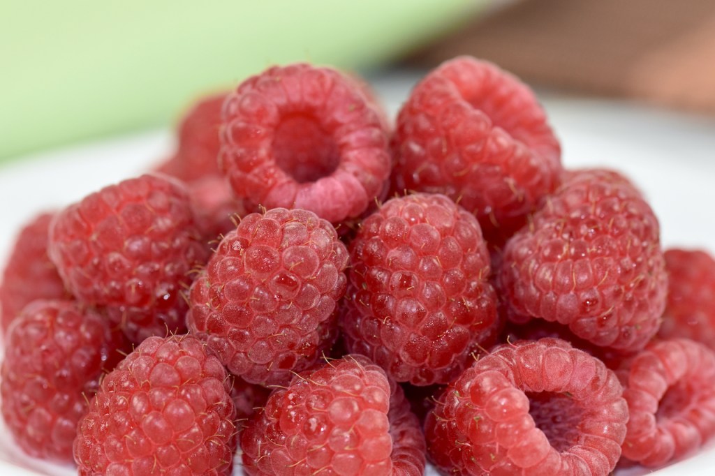 mehrere Himbeeren auf einem weißen Teller