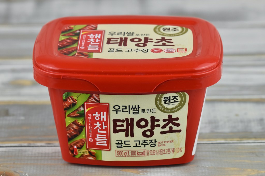 gekaufte koreanische Chilipaste (Gochujang). Die rote Verpackung ist mit koreanischen Schriftzeichen bedruckt.