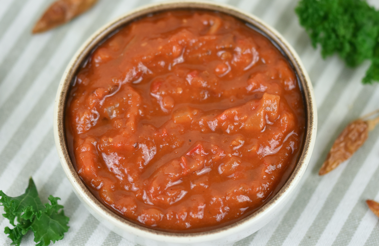 Mexikanische Salsa mit Tomaten und Paprika in weißer Schale.