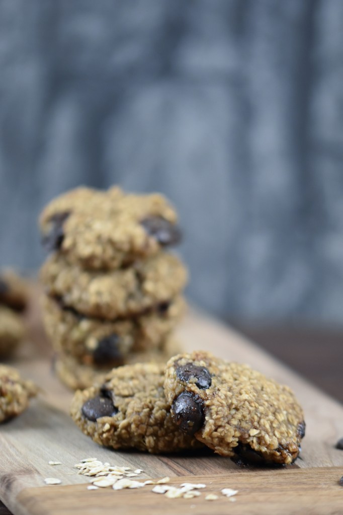 Weiche Chocolate Chip Cookies auf Holzbrett. Hintergrund dunkel.