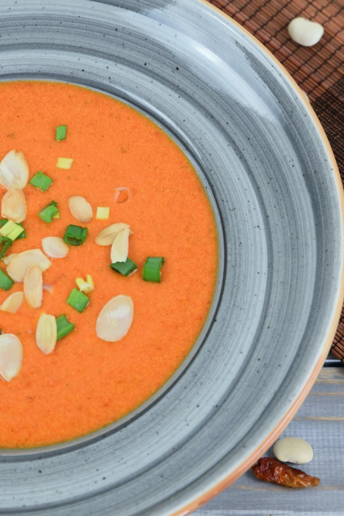Cremige Paprikasuppe mit Kräutern in einem grauen Teller.