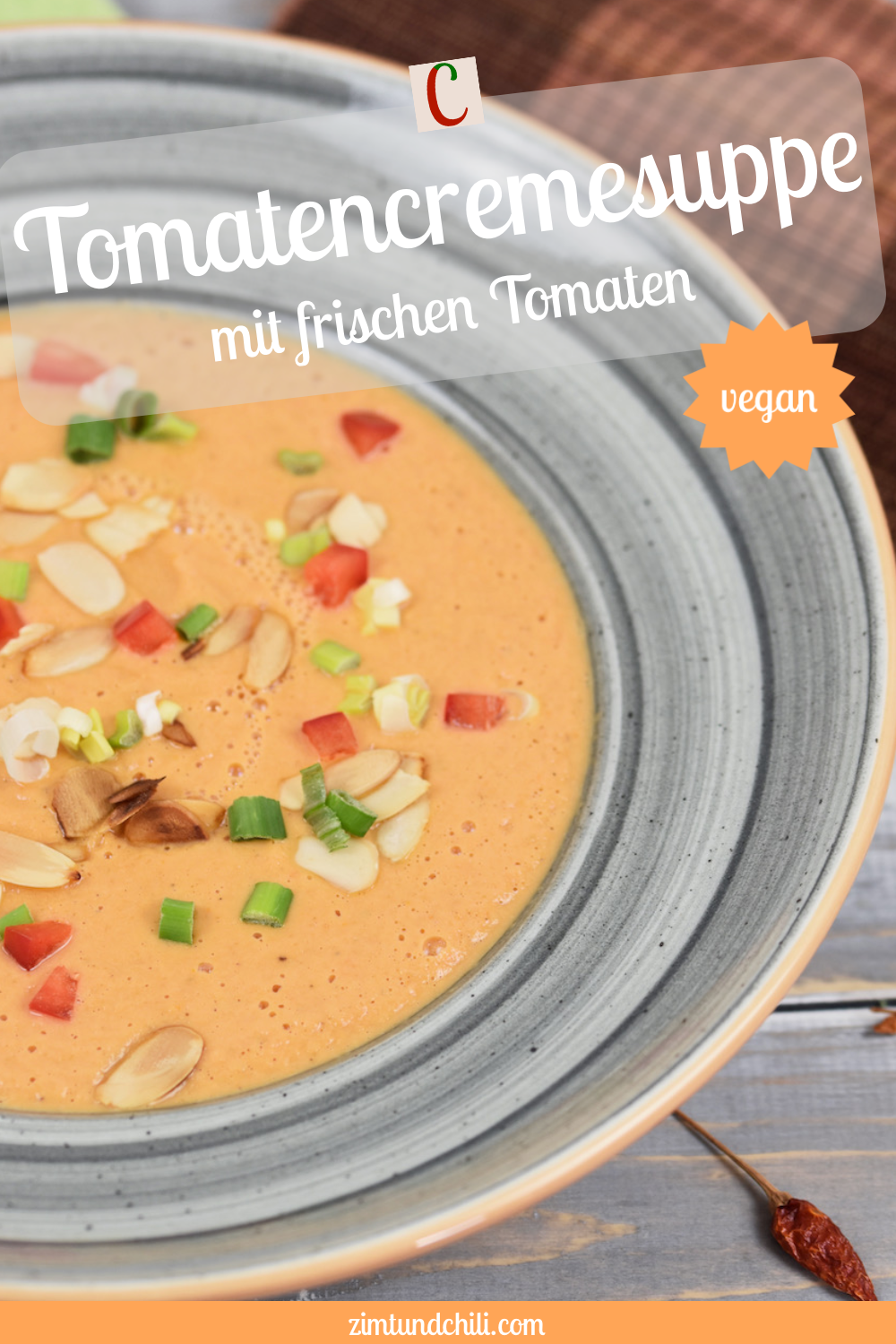 Tomatencremesuppe in grauem Teller. Der Teller ist nur halb zu sehen. Hintergrund hell. Beschrifteter Pin