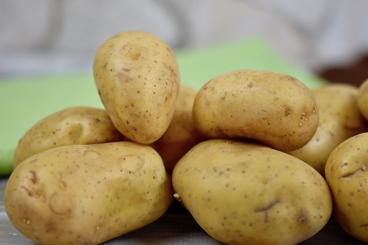 mehrere Kartoffeln mit Schale liegen zusammen