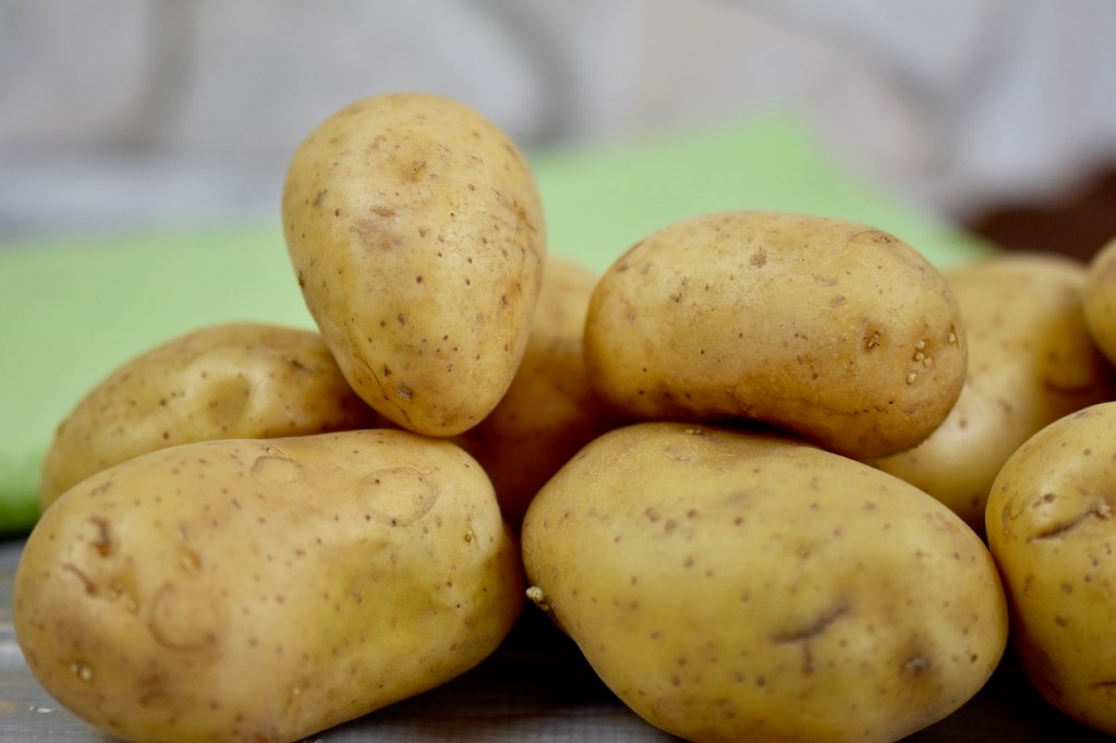 mehrere Kartoffeln mit Schale liegen zusammen