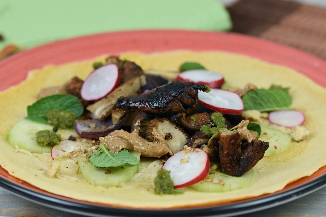Pilz-Shawarma mit Tortilla auf rotem Teller.