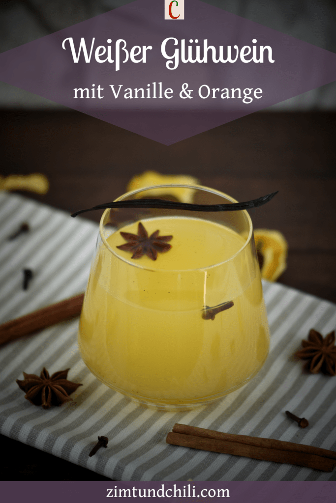 Weißer Glühwein mit Vanille und Orange in einem Glas ohne Stiel. Beschrifteter Pin.