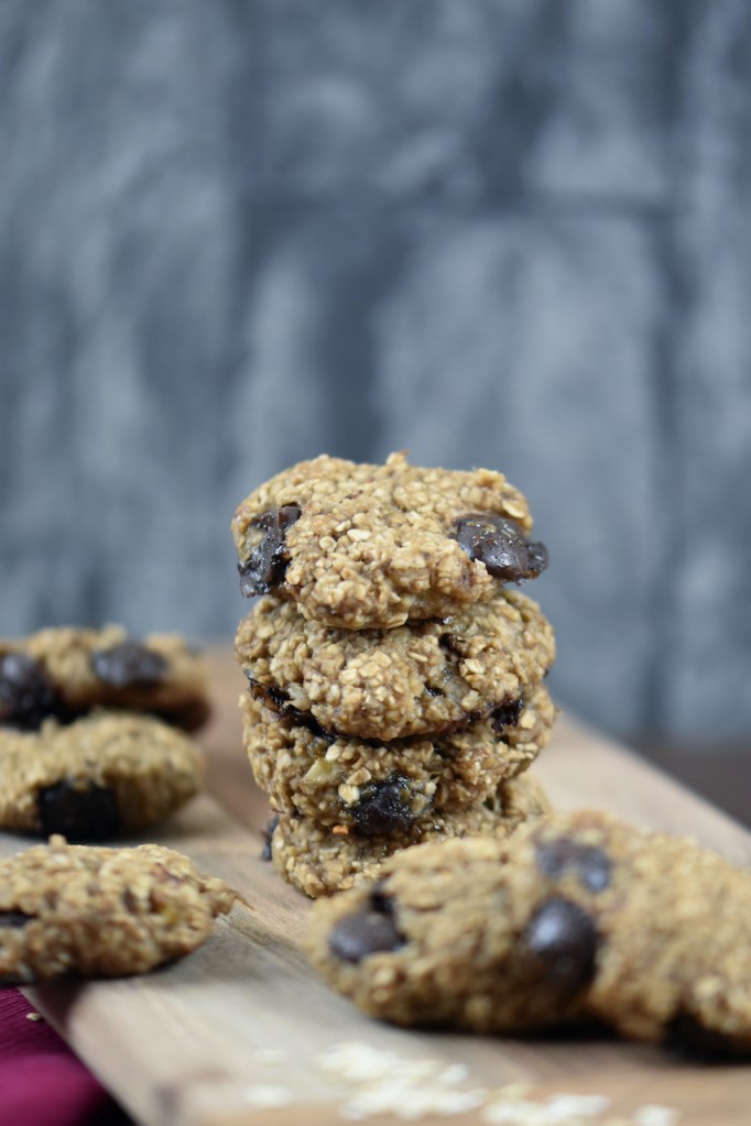 Weiche Chocolate Chip Cookies auf Holzbrett. Hintergrund dunkel.