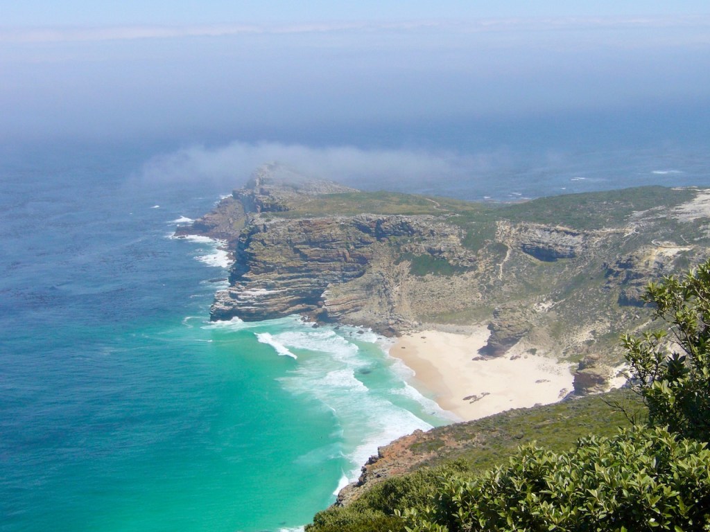 kleiner weißer Strand mit türkisem Meer und schroffen Felsen von oben fotographiert. Kap der guten Hoffnung - Südafrika