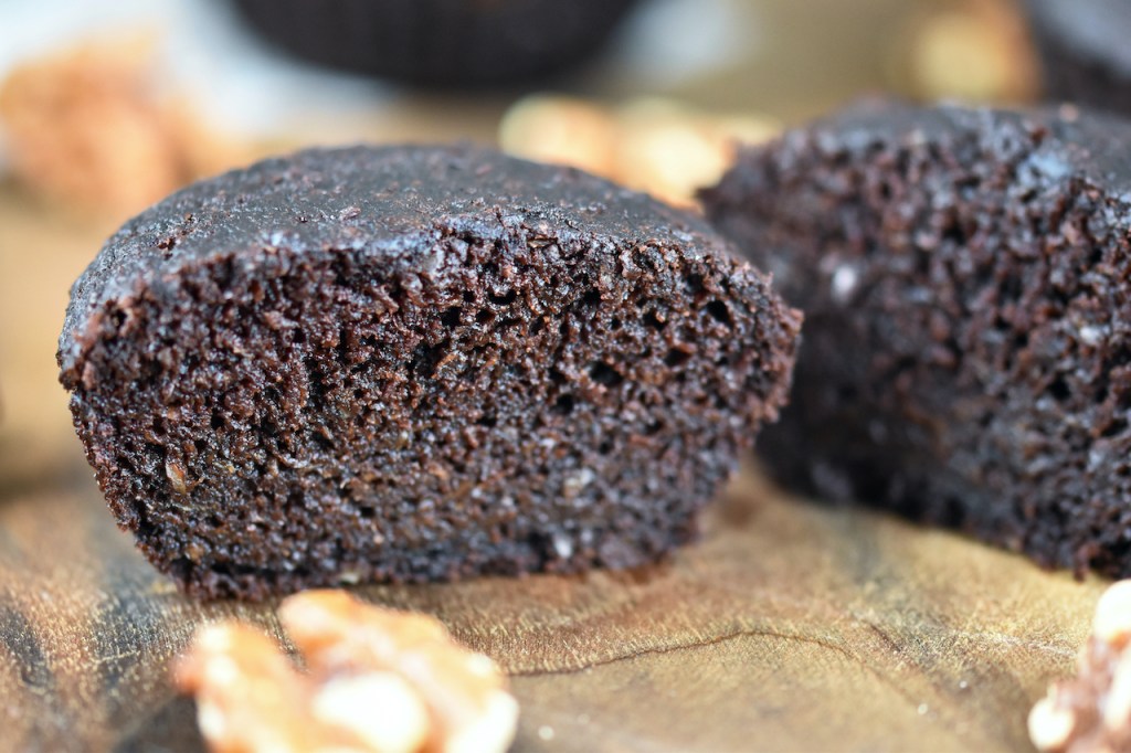 Saftiger Brownie mit Walnüssen aufgeschnitten auf Holzbrett.