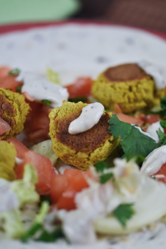 Falafel Wrap mit Gemüse, Salat und Sauce. Noch nicht aufgerollt.