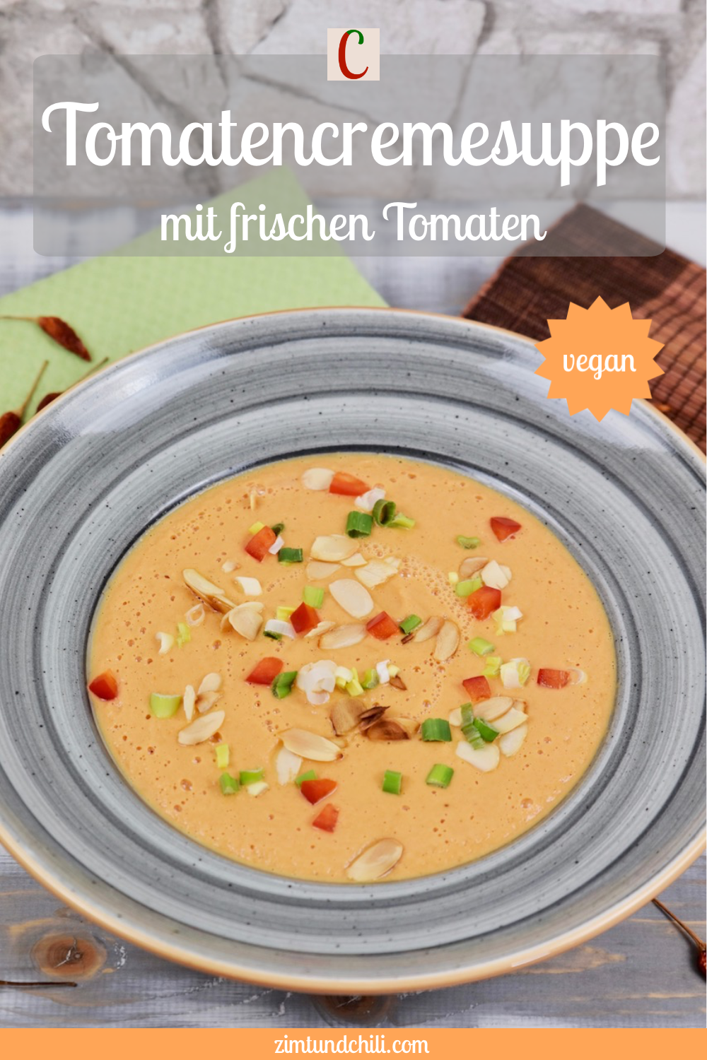 Tomatencremesuppe in grauem Teller. Hintergrund hell. Beschrifteter Pin