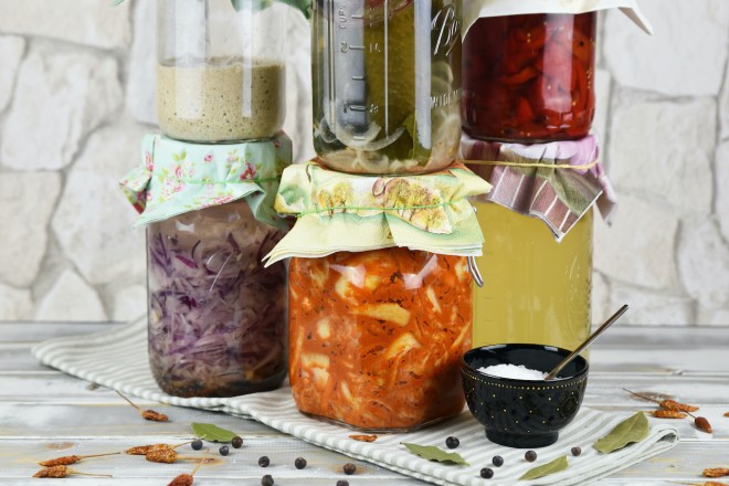 Einmachgläser gefüllt mit verschiedenen Fermenten der wilden Fermentation. Hintergrund hell.