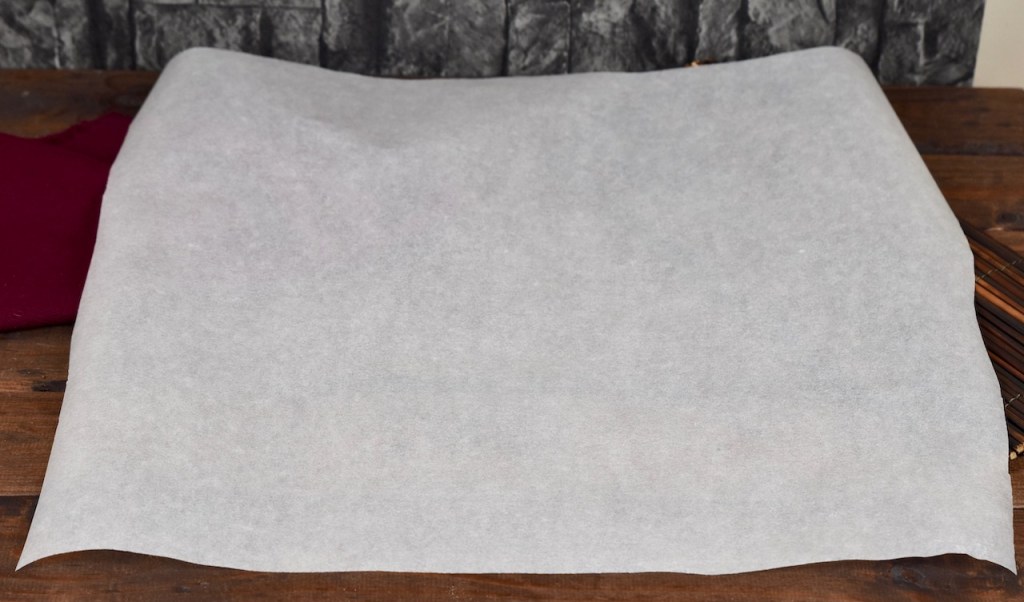 Ein Blatt weißes Backpapier auf dunklem Untergrund.