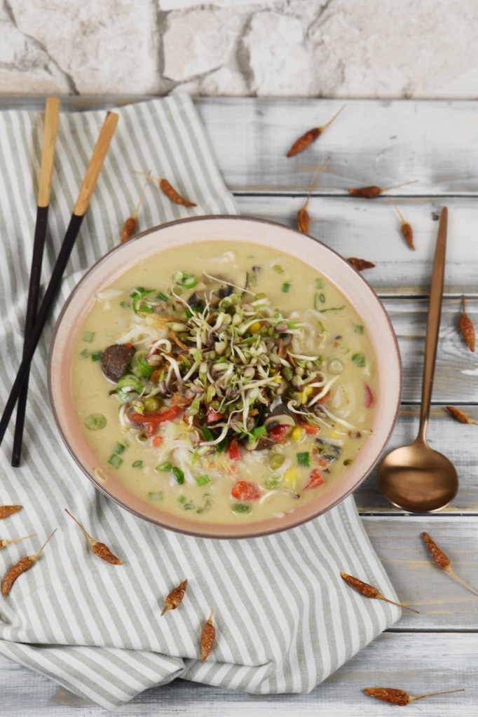 Thai-Suppe mit Kokosmilch und Zitronengras in heller Schale.