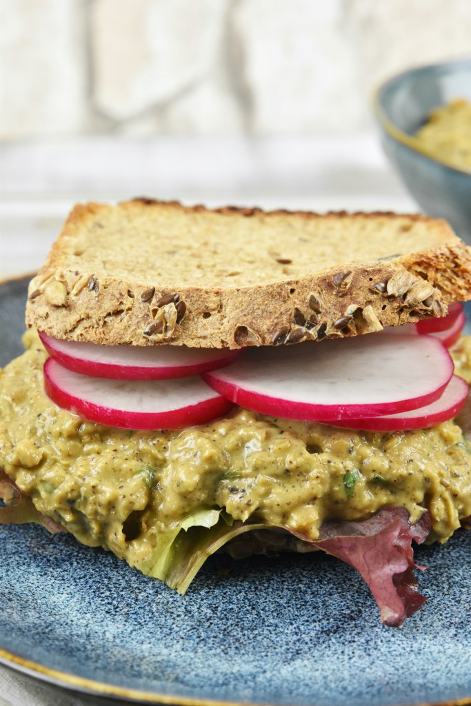 Veganer Thunfischsalat aus Kichererbsen auf einem Sandwich mit Radieschen